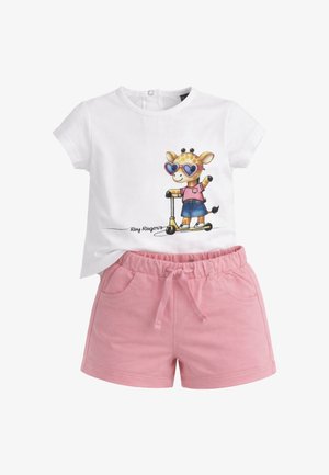 Camicia bianca a maniche corte con giraffa che indossa occhiali da sole a forma di cuore su uno scooter, abbinata a pantaloncini rosa con coulisse e tasche.