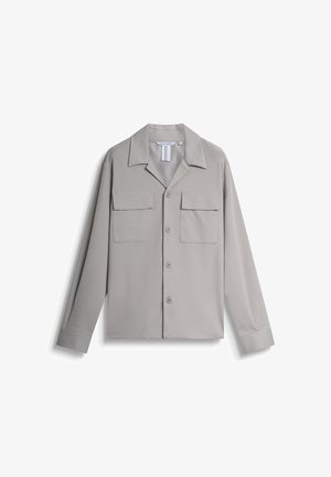 Chemise boutonnée gris clair avec un col pointu, deux poches poitrine et des manches longues. Texture de tissu lisse, design minimaliste.