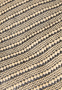Tessuto tessuto con un motivo a scacchiera in fibre nere e naturali alternate, creando un aspetto testurizzato e dimensionale.