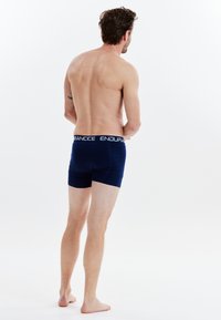 Donkerblauwe boxershorts met een witte elastische tailleband waarop de tekst "ENDURANCE" staat. De stof lijkt glad en aansluitend, met een op maat gemaakt ontwerp.