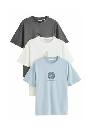 Tres camisetas de manga corta: una gris, una blanca con letras doradas y una azul claro con un estampado gráfico. Todas están hechas de algodón.