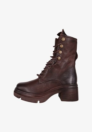 Brun læderankelstøvle med en chunky hæl, snørebånd foran og dekorative metalknapper på siden. Tekstur overflade og rundet tå.