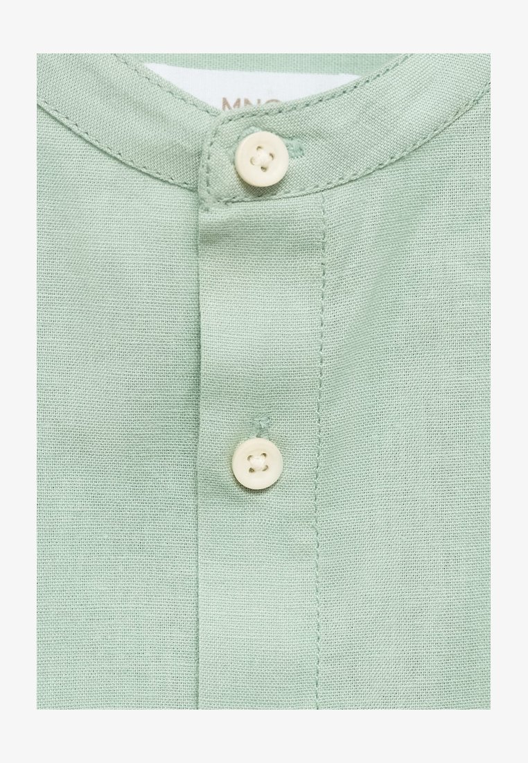 Ljusgrön skjorta med krage, prydd med två vita knappar och ett texturerat, vävt tyg.