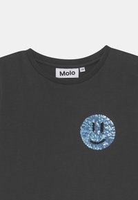 Černé tričko s kulatým výstřihem, ve středu s modrým flitrovým úsměvem. Na límci je viditelná značka "Molo".