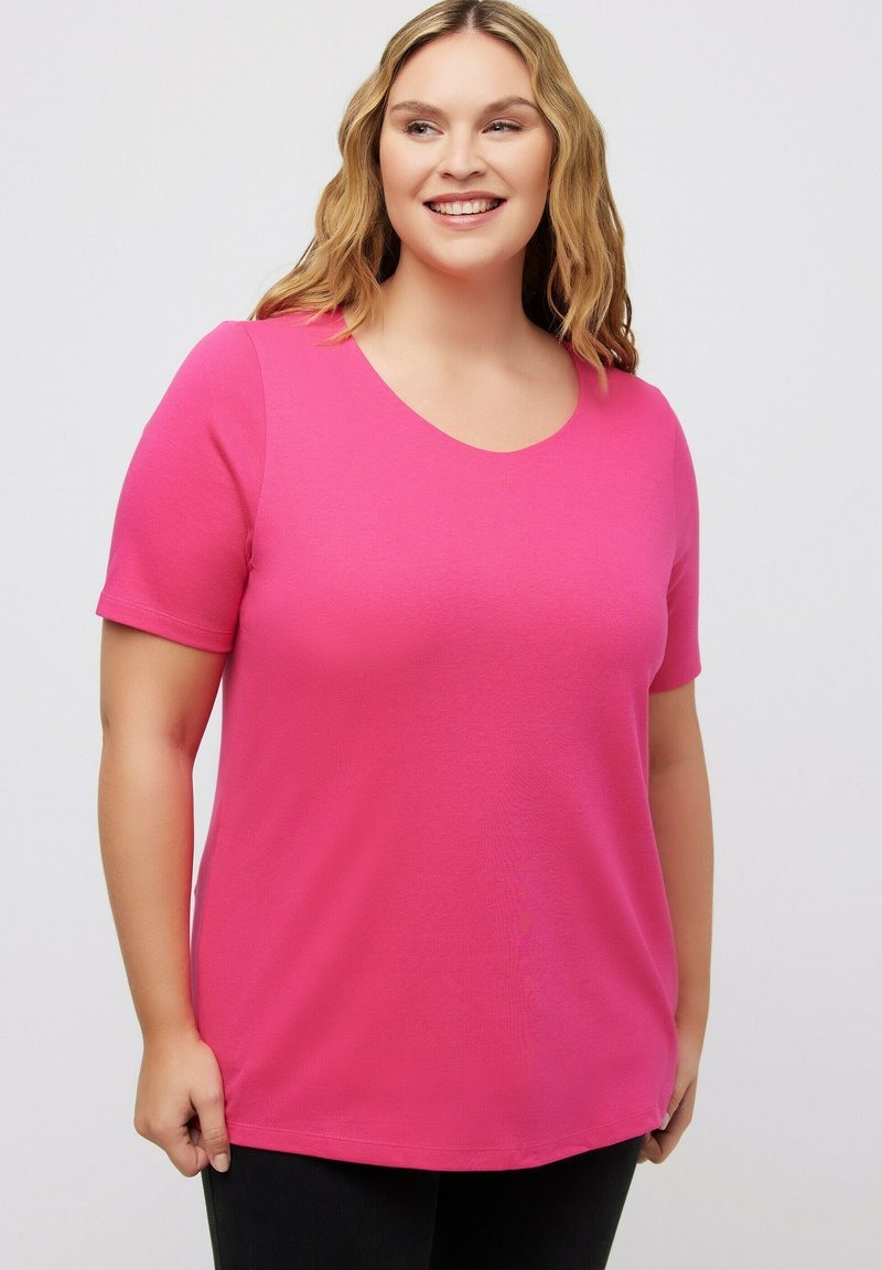 Korte mouw, roze t-shirt met een ronde hals, gemaakt van zachte, lichte stof. Heeft slanke zijsplitten aan de zoom voor meer bewegingsvrijheid.