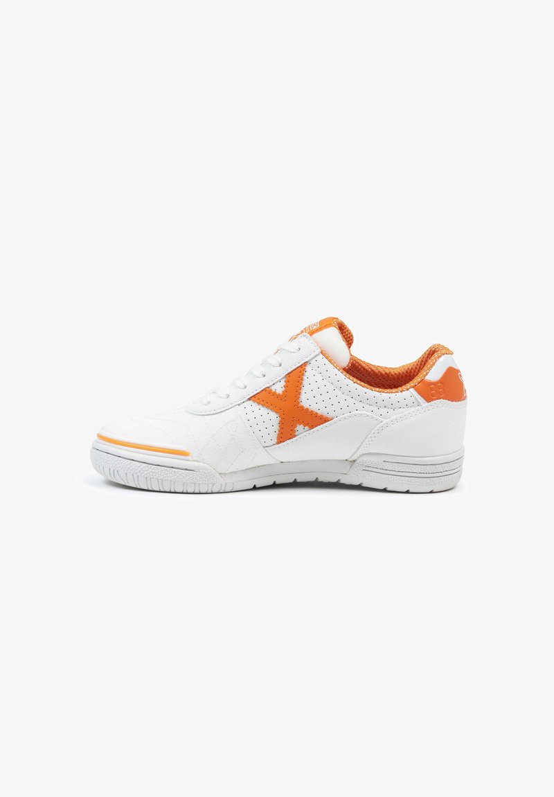 Zapatilla blanca con acentos naranjas, que presenta paneles perforados, tela texturizada y una suela de goma. El diseño incluye un prominente logo naranja en forma de "X".