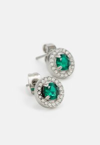 Silver stud earrings featuring a central green gemstone surrounded by clear rhinestones in a circular setting.