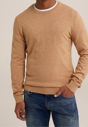 Brauner strukturierter Pullover mit Rundhalsausschnitt und Rippenbündchen, kombiniert mit blauer Denim-Jeans. Der Pullover hat eine melierte Stoffoberfläche.