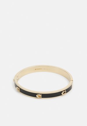 Bransoletka na rękę w kolorze złota i czerni z emalią, ozdobiona małymi złotymi akcentami w kształcie potknięć konia, o okrągłym kształcie i z zapięciem na zawiasach.