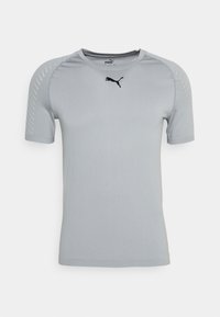 Camiseta atlética de manga corta en gris claro, hecha de tela transpirable, con cuello redondo y logo negro de PUMA en el pecho.