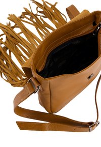 Brązowa skórzana torba crossbody z frędzlami, wewnętrzną kieszenią na zamek i regulowanym paskiem. Posiada teksturowane wykończenie i subtelne logo.
