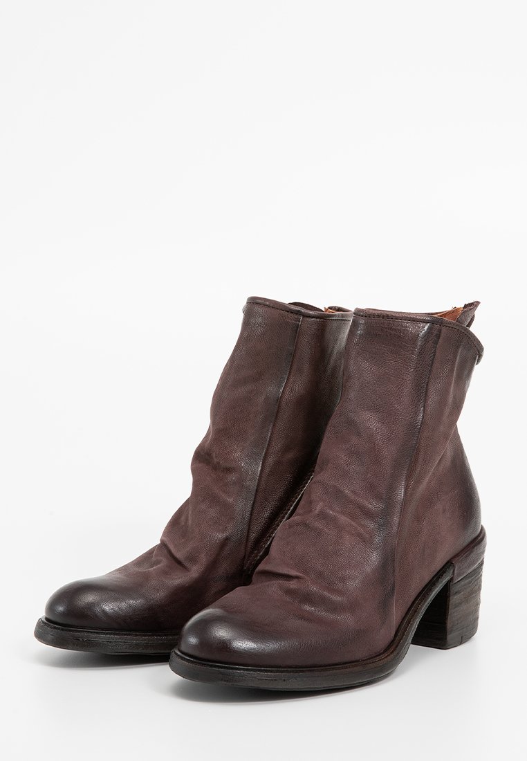 Smeđe kožne gležnjače s mekom teksturom, ležernim dizajnom, zaobljenim vrhom i srednjim drvenim blok potplatom. Pogodne za različite stilove.