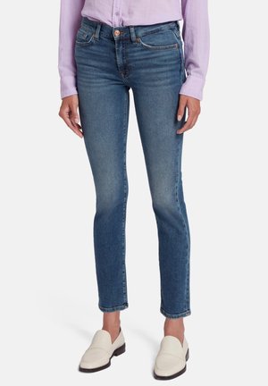 Skinny jeans in middelblauwe denim, met een middelhoge taille, subtiele wassing, vijfzakkenontwerp en afgewerkte zoom. Witte instappers.
