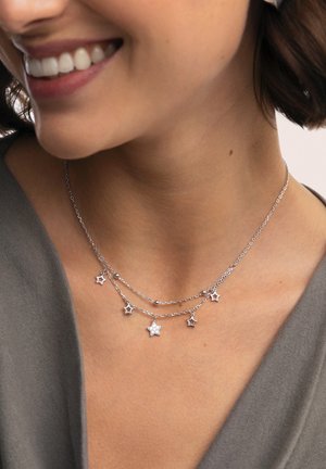Collar de capas plateado con colgantes en forma de estrella, que incluye una estrella con un acento brillante y pequeñas cuentas metálicas a lo largo de las cadenas.