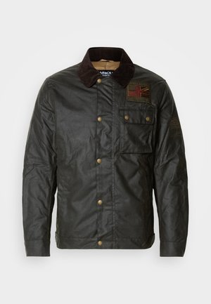 Waxed cotton jacket in dark green with a corduroy collar, featuring a Union Jack patch and gold-tone snap buttons. Includes chest pocket.