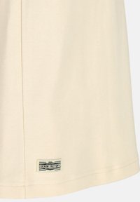 Beige T-shirt made of soft fabric featuring a straight cut, visible stitching, and a branded label at the hem.