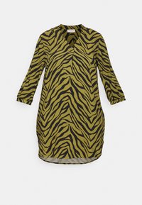 Zielona tunika w formie sukienki z krótkim rękawem w czarne paski zebry, z dekoltem w serek i zaokrąglonym dołem, wykonana z lekkiego materiału.