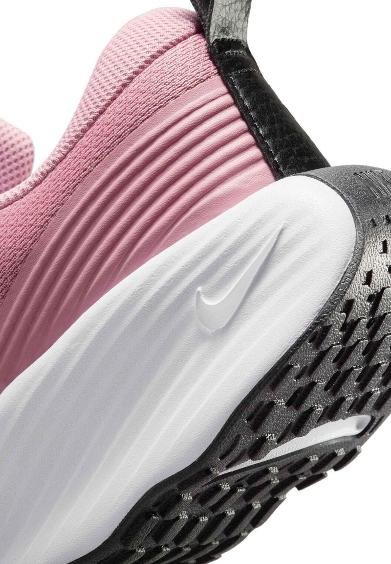Baskets Nike avec une tige en mesh rose, des accents texturés noirs, une semelle intermédiaire blanche et une semelle extérieure en caoutchouc noir dotée de petites nubs de traction.