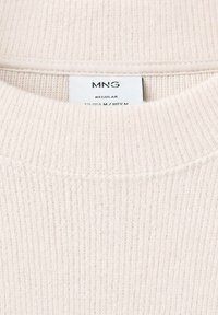 Suéter de punto beige claro con textura acanalada, escote redondo y una etiqueta que muestra "MNG REGULAR." Tejido suave con un diseño ligeramente casual.