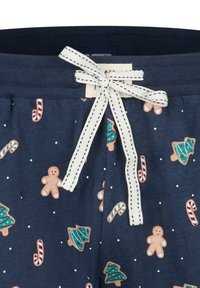 Marineblauwe pyjamashorts met feestelijke peperkoekmannetjes, kerstbomen en zuurstokpatronen; voorzien van een witte trekkoord met zwarte stiksels.