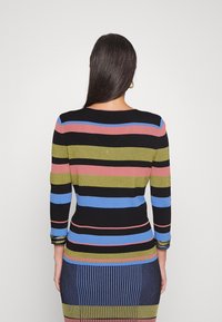 Ribbed knit pitkähihaisessa paidassa on vaakasuorat raidat mustassa, vaaleanpunaisessa, sinisessä ja vihreässä. Rakenteellinen siluetti, jossa on pyöreä kaulus.