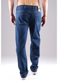 Blaue Jeans aus Denim mit geradem Schnitt, ausgestattet mit genähten Gesäßtaschen und einem Markenschild am Bund. Unterer Saum leicht ausgefranst.