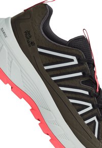 Sportschuhe mit braunem Mesh-Obermaterial, schwarzen Akzenten, reflektierenden weißen Streifen und einer pinkfarbenen Gummisohle mit strukturiertem Profil.