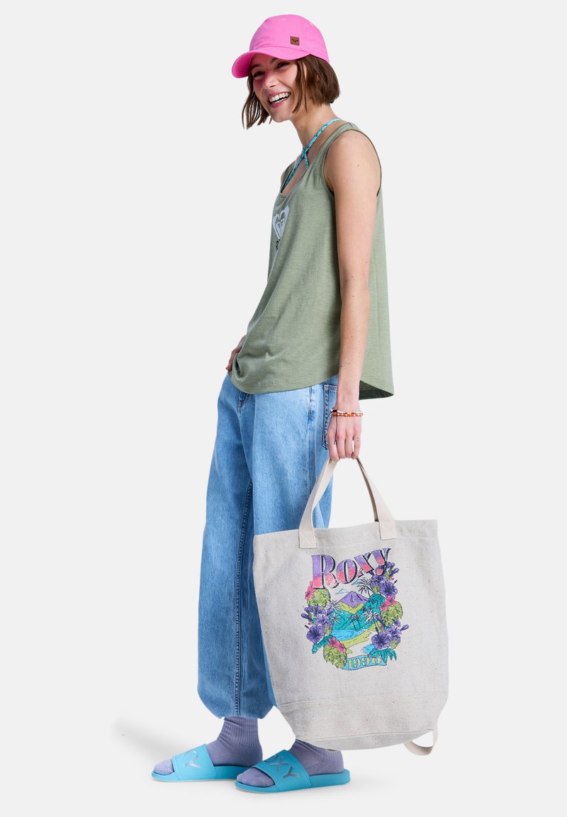 Ανοιχτό πράσινο τοπ χωρίς μανίκια, φαρδιά ανοιχτό μπλε τζιν, ροζ καπέλο και μπλε σανδάλια. Μπεζ τσάντα ώμου με πολύχρωμο λουλουδάτο σχέδιο και χερούλια.