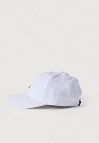 Καπέλο μπέιζμπολ από λευκό ύφασμα, με καμπύλη γείσο, οπές αερισμού και μικρή λεπτομέρεια λογότυπου στο μπροστινό μέρος.
