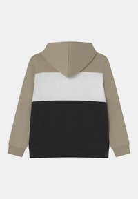 Sudadera con capucha de diseño en tres colores: parte superior beige, centro blanco y secciones inferiores negras. Fabricada en tela suave, con puños acanalados.