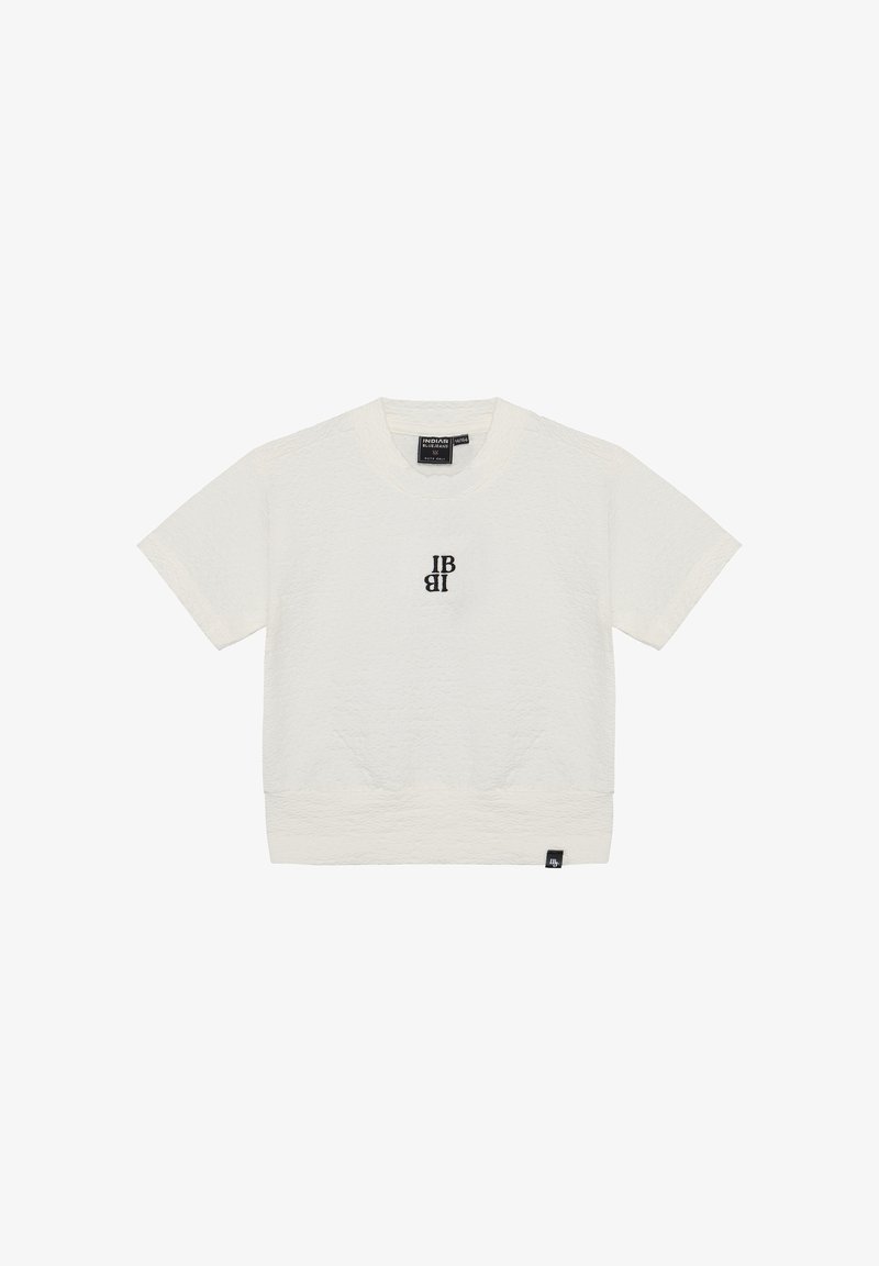 Helle beige kurzärmlige T-Shirt aus strukturiertem Stoff. Mit einem schwarzen Logo auf der Brust und einem schwarzen Etikett am Saum.