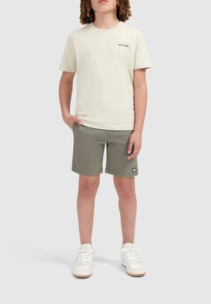 Crème t-shirt met "BALLIN'" logo, gecombineerd met olijfgroene shorts en witte sneakers. Casual fit met een soepele stof en minimale details.