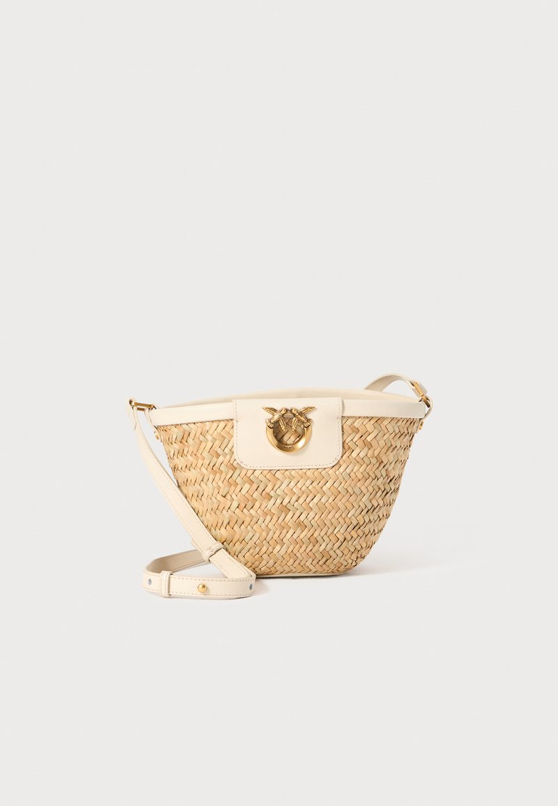 Bolsa transversal de palha trançada com um acabamento em pele de cor creme, fecho redondo em metal dourado e alça ajustável. Superfície texturizada, tons neutros.