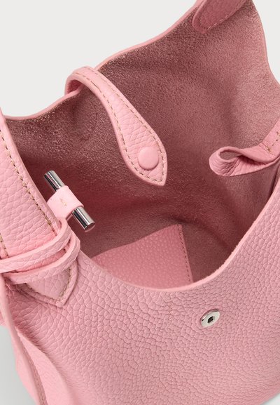 Roosa tekstureeritud nahast kott, mille sees on sile pind, millel on metallist magnetiline sulgur ja detailne õmblemine servadel.