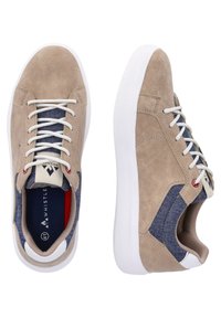Beige suede sneakers with white soles, blue denim accents, and gray laces. Features a logo on the tongue and contrasting stitching details.