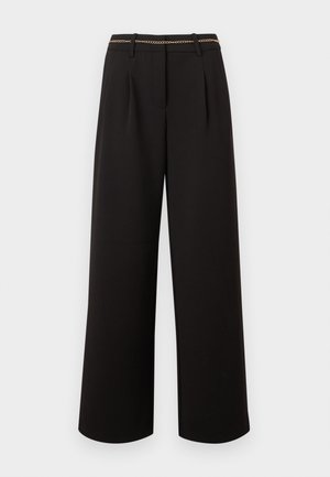 Μαύρο παντελόνι με φαρδιά μπατζάκια, πιέτες, θηλιές για ζώνη και λεπτή χρυσή αλυσίδα ζώνης σε απλό ανοιχτό φόντο.