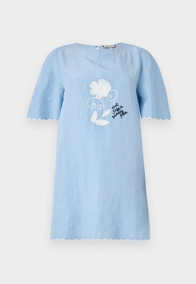 Šviesiai mėlyna trumpomis rankovėmis suknelė su iškirptais kraštais, papuošta baltais gėlių siuvinėjimais ir juodu tekstu "Ne tik gražus veidas."