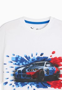 Camiseta blanca con un gráfico de un coche de carreras rodeado de diseños en píxeles azules y rojos, destacando la velocidad y la acción.