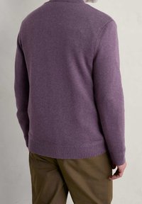 Maglione lavorato a maglia viola con scollo rotondo, polsini e bordo a coste, abbinato a pantaloni beige. Design pulito, spessore medio, texture liscia.