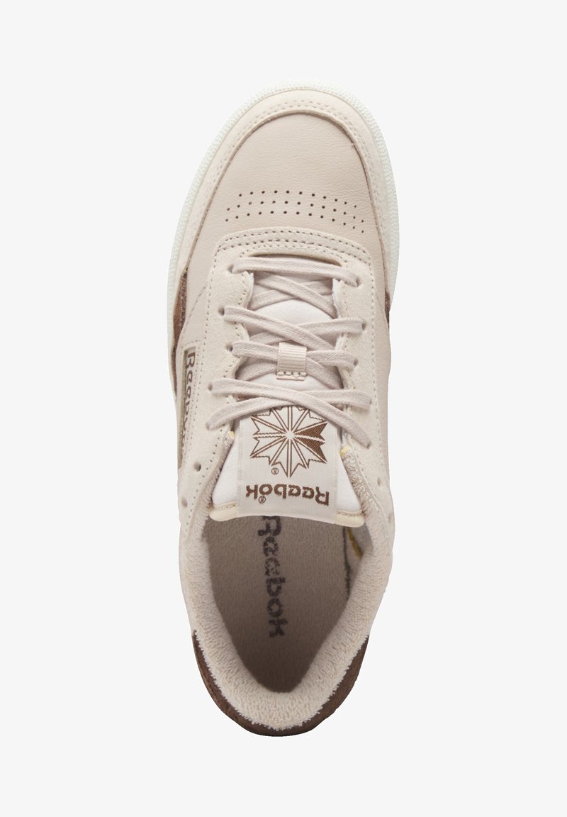 Baskets Reebok beige vues de dessus, avec des lacets, un bout perforé et une languette de marque avec logo étoile.