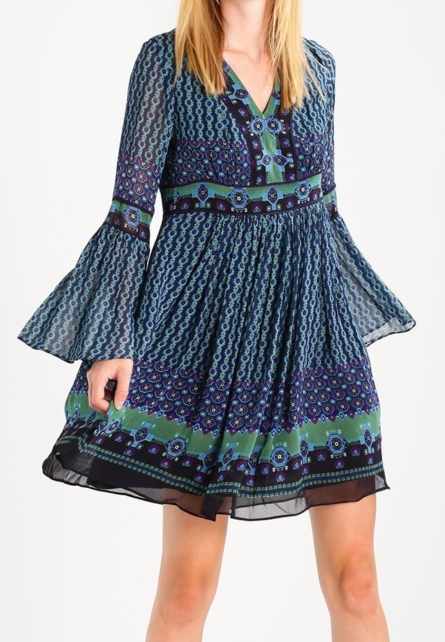 Robe à motifs bleus et verts avec manches longues évasées, décolleté en V et taille froncée. Confectionnée en tissu léger avec un ourlet à plusieurs couches.