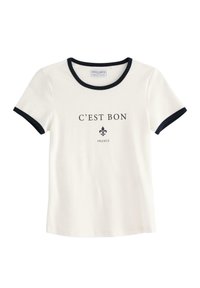 Witte katoenen t-shirt met zwarte ringerhals en mouwen. Aan de voorkant staat bedrukt de tekst "C'EST BON" en een fleur-de-lis ontwerp.