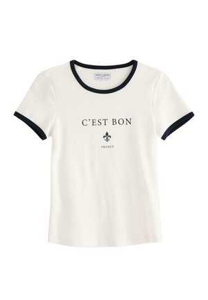 Witte katoenen t-shirt met zwarte ringerhals en mouwen. Aan de voorkant staat bedrukt de tekst "C'EST BON" en een fleur-de-lis ontwerp.