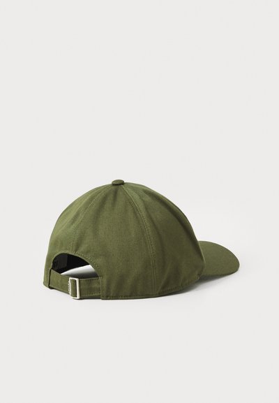 Green cotton baseball cap with a curved brim, adjustable strap at the back, and a rounded top with visible stitching details.