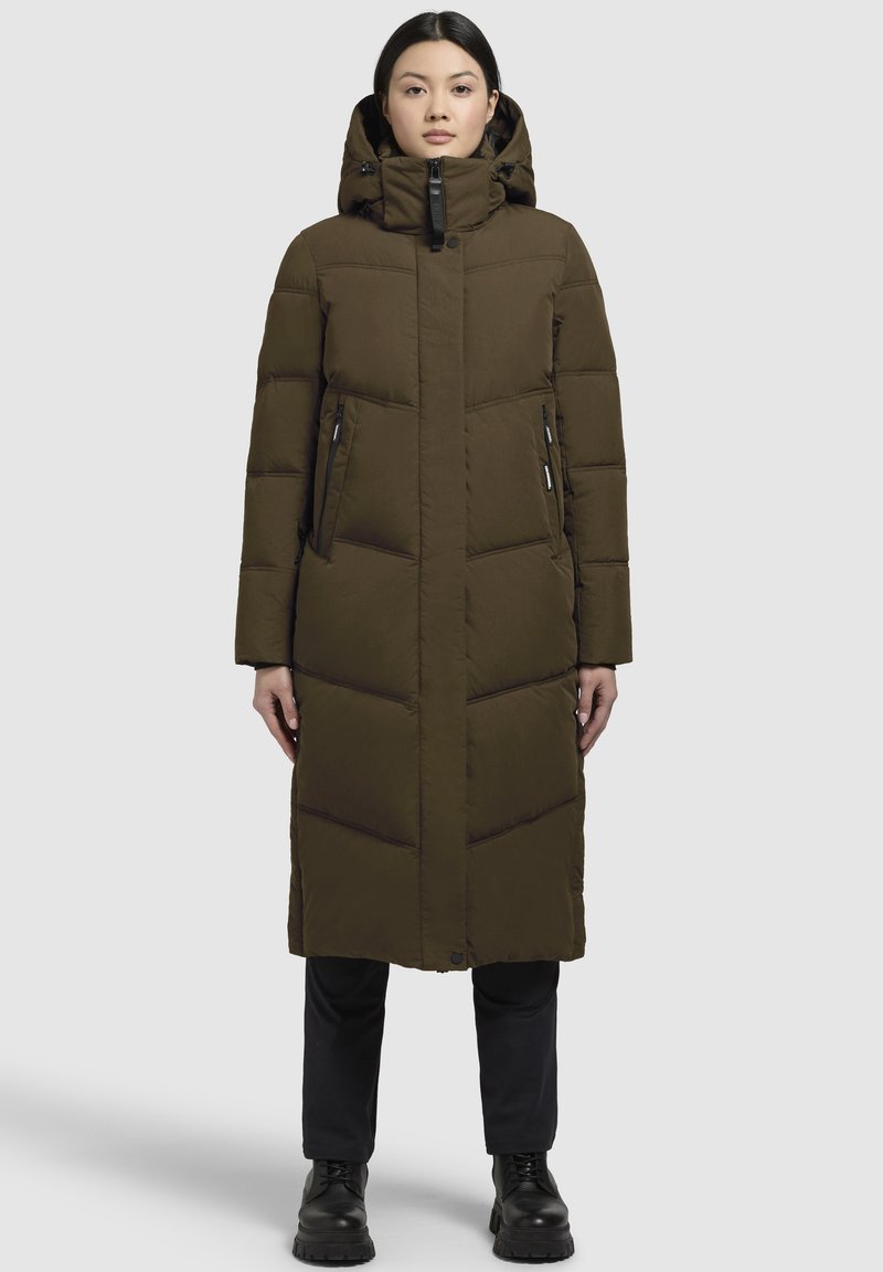 Dlouhý hnědý péřový kabát s kapucí, vertikálně prošívaný vzor, boční kapsy a voděodolným zipem. Těsný střih a hladká textura.