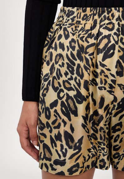 Shorts de estampado de leopardo hechos de tejido suave con una cinturilla elástica; presentan manchas negras sobre un fondo beige, diseño plisado y bolsillos laterales.