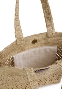 Beige gehaakte draagtas met twee handvatten, een open bovenkant en een verwijderbare lichte stoffen zak aan de binnenkant.