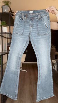 Lys blå denim flared jeans med middels høy livhøyde, frontlommer og synlig søm. Stoffet har en falmet finish.