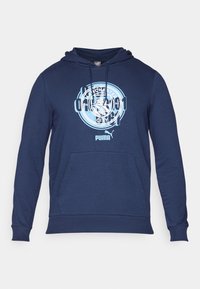 Felpa navy con cappuccio e tasca a marsupio, con un grande logo di Manchester City in azzurro chiaro e il logo Puma. Tessuto morbido e polsini a costine.