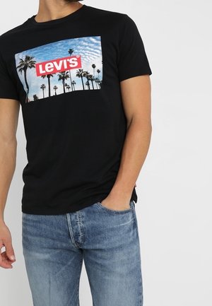 Czarny bawełniany t-shirt z grafiką na przodzie przedstawiającą palmy oraz czerwonym logo "Levi's". Okrągły dekolt i krótkie rękawy. Luźny krój.